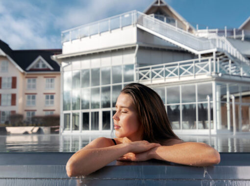 En kvinna med slutna ögon i utomhuspoolen vid Selma spa.