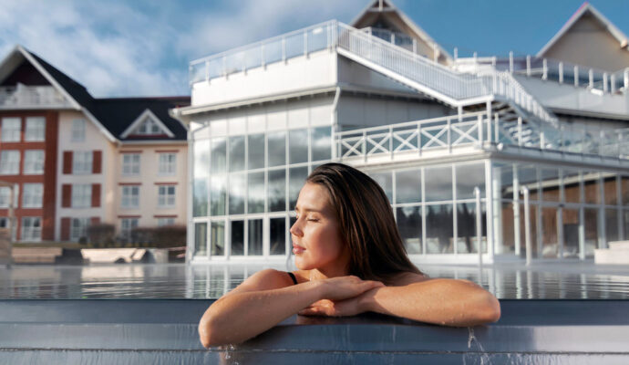 En kvinna med slutna ögon i utomhuspoolen vid Selma spa.