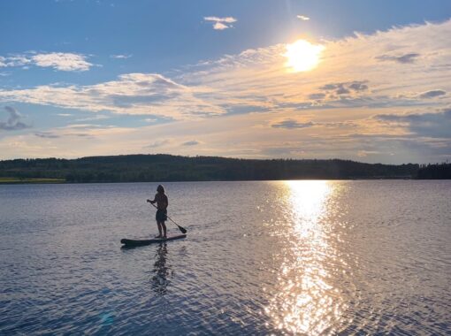 SUP-i-Sunne-oppet-vatten-med-motljus